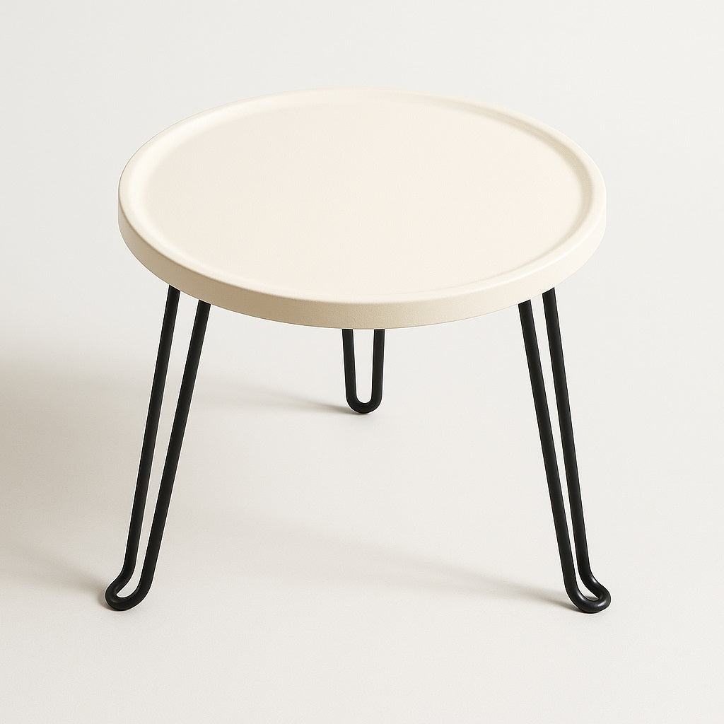 Table basse ronde blanche en métal avec pieds noirs, vue en angle, style minimaliste moderne.