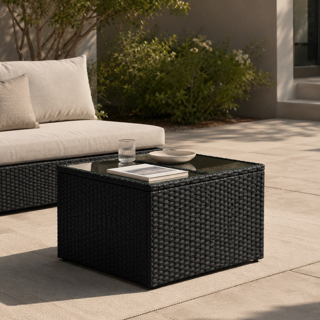 Table basse de jardin noire avec plateau en verre dans un salon d’extérieure élégant et moderne.