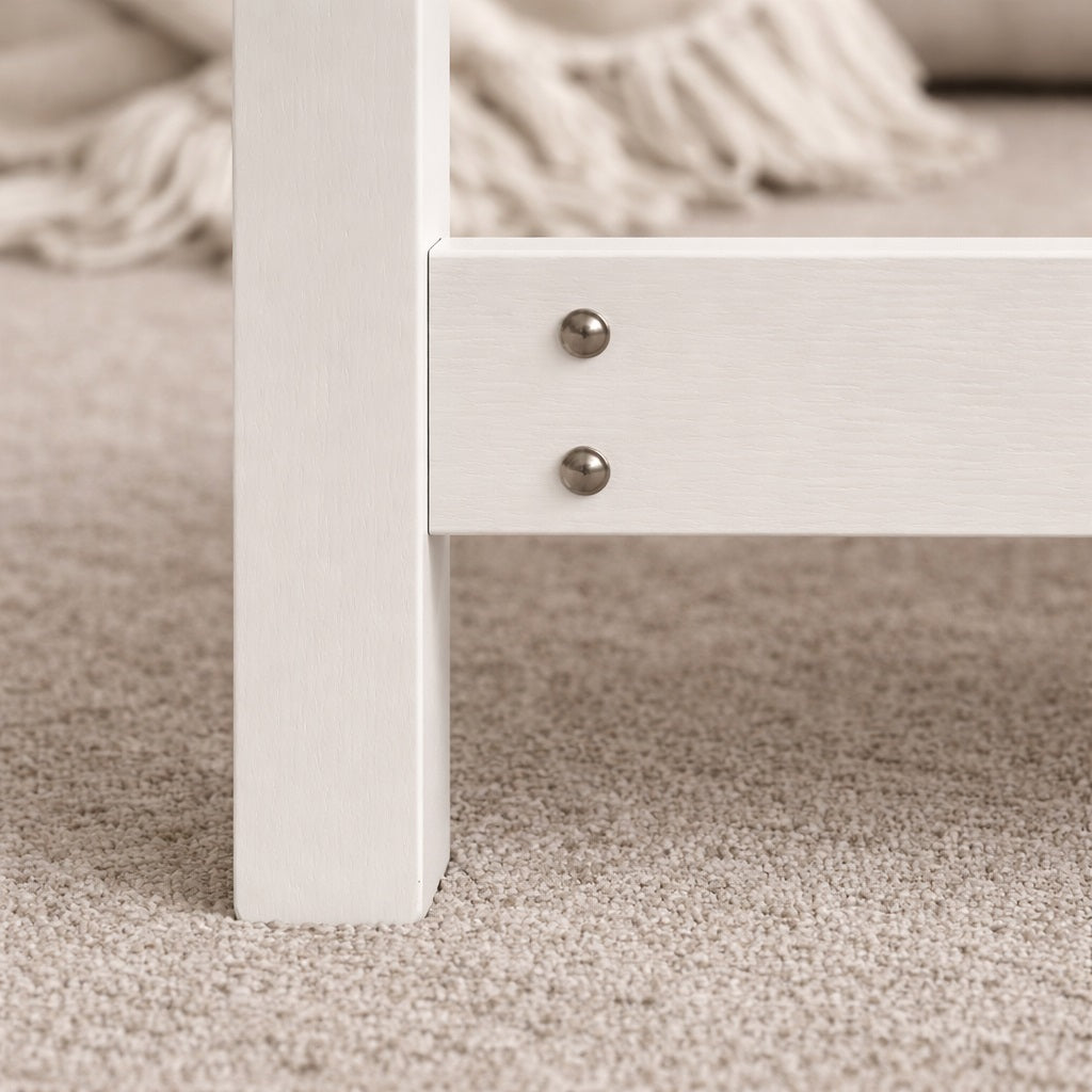 Détail du piètement en bois d’une table basse blanche, finition soignée et structure robuste pour salon.