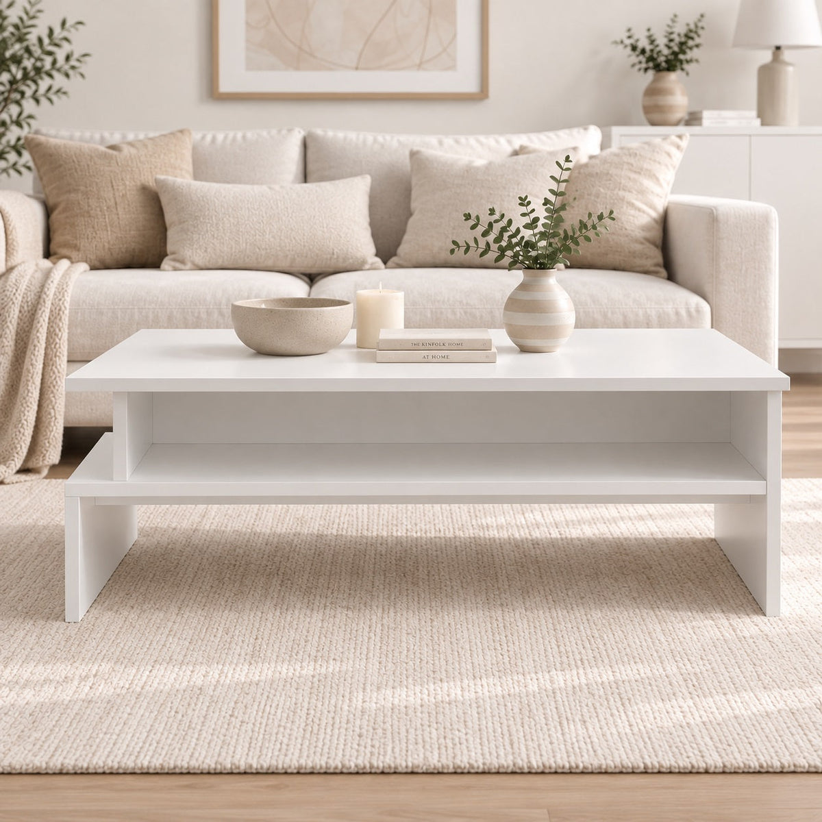 Table basse de salon blanche avec étagère de rangement, vue de face dans un intérieur moderne aux tons naturels.