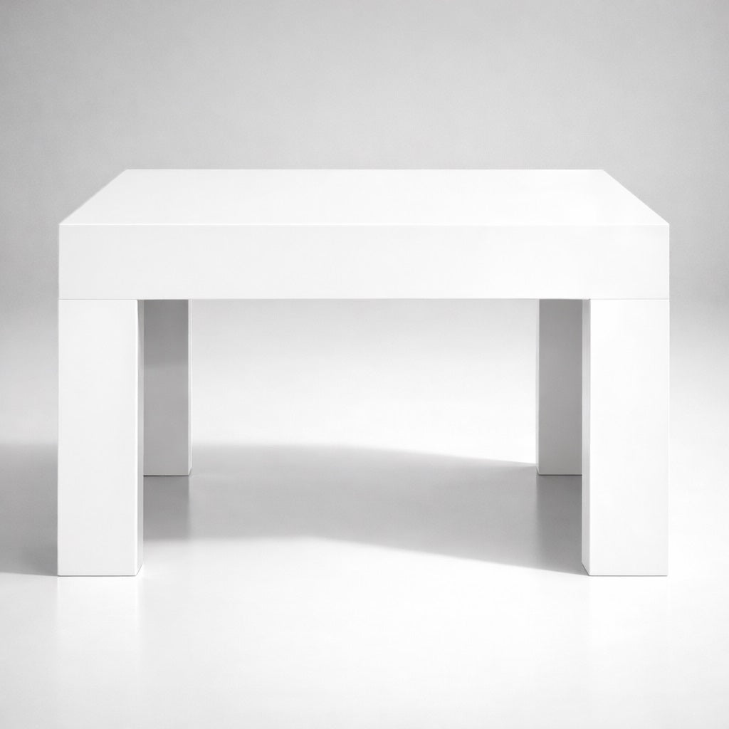 Table basse blanche vue de face, lignes nettes et structure massive pour table basse de salon moderne.
