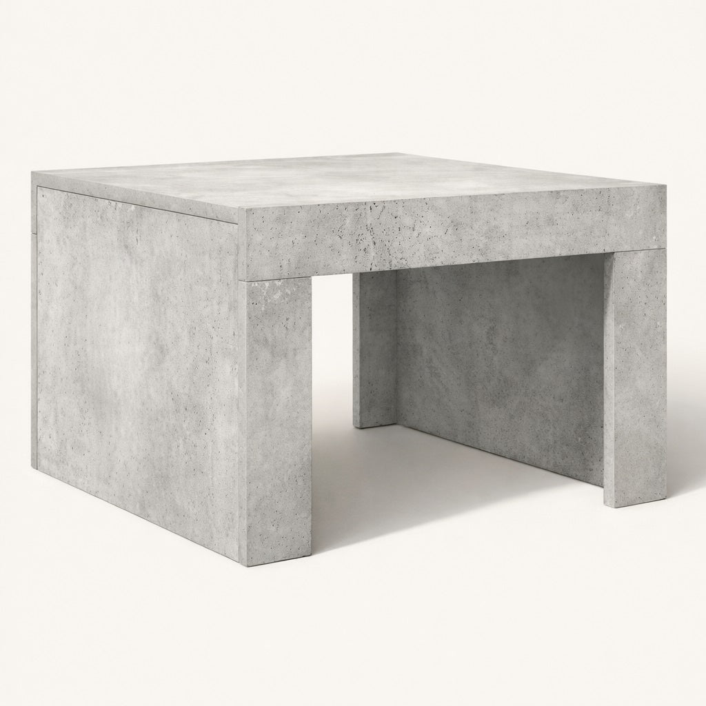 Table basse grise à finition minérale, design architectural et volumes pleins pour table basse de salon.